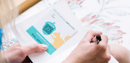 Someone writing a card with an addSQUIRREL QR code inside